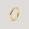 A polished yellow gold band ring with a smooth, rounded profile, shown on a neutral light gray background.
