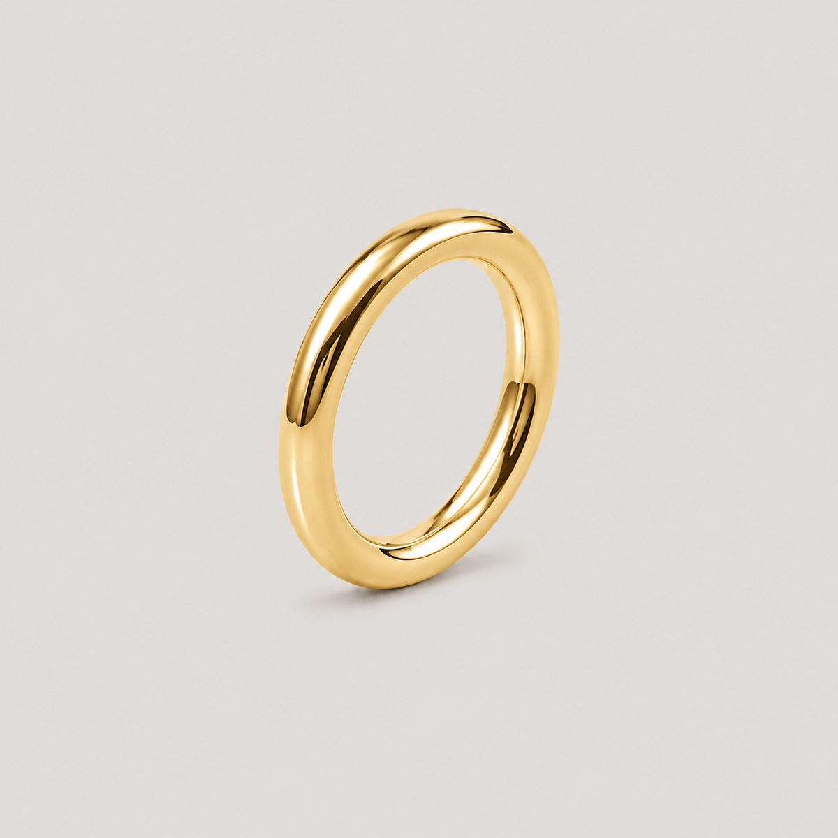 A polished yellow gold band ring with a smooth, rounded profile, shown on a neutral light gray background.