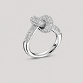 A silver knot ring with pavé-set clear stones, shown on a neutral light gray background.