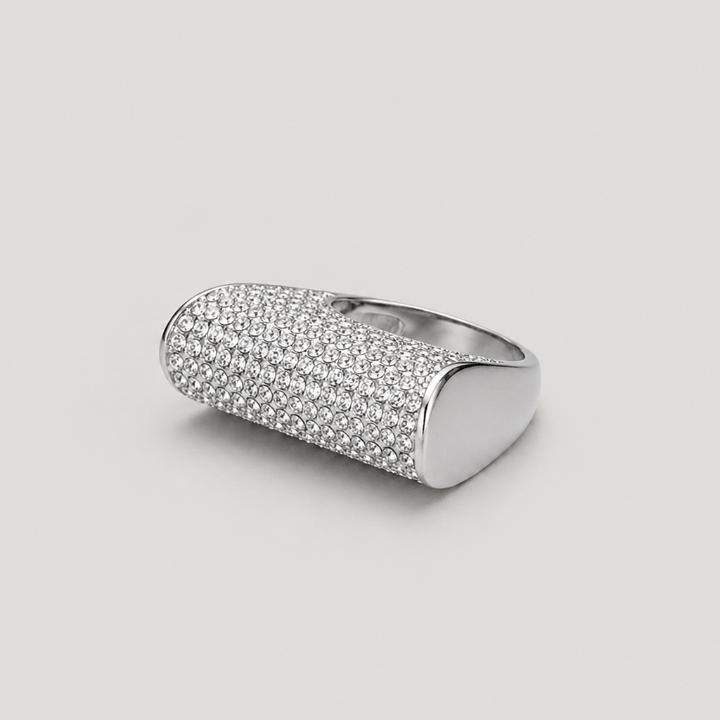 A silver-toned signet ring with a textured, pavé-set oval face, photographed on a neutral light gray background.