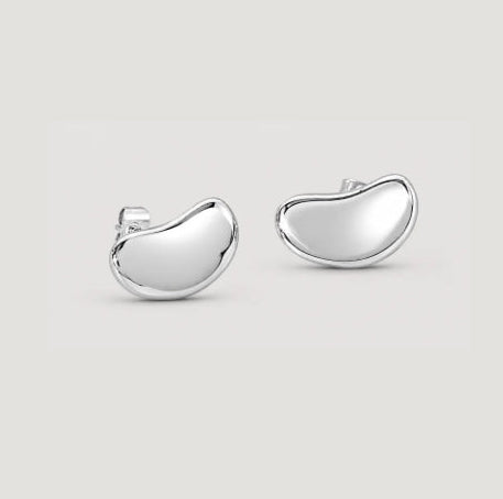 A pair of polished silver shaped stud earrings on a light gray background.