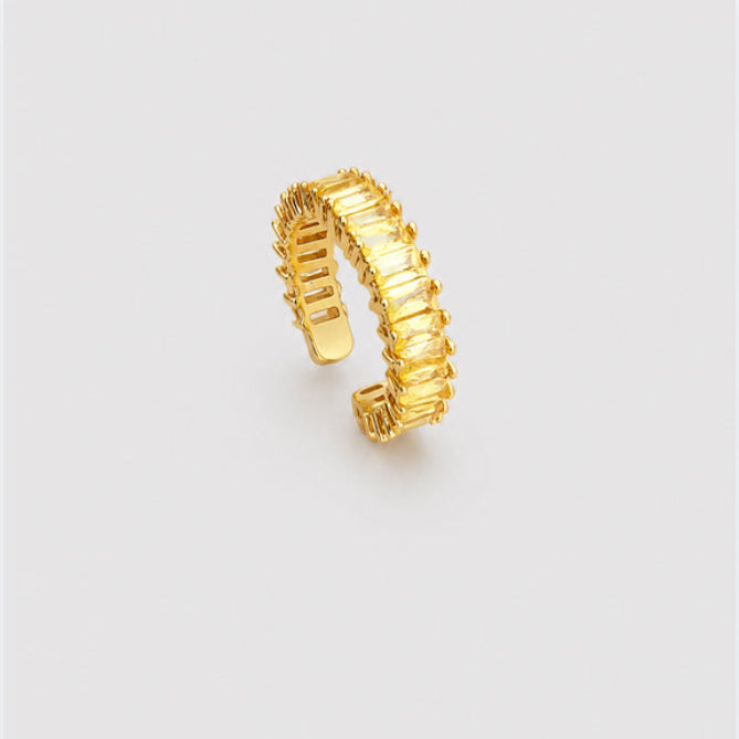 A textured gold ring with a segmented, ribbed design, shown on a plain light gray background.