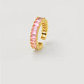 A gold-plated adjustable ring featuring a row of rectangular pink gemstones, set against a plain light gray background.
