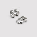 A pair of polished silver huggie hoop earrings shown on a clean, light gray background.