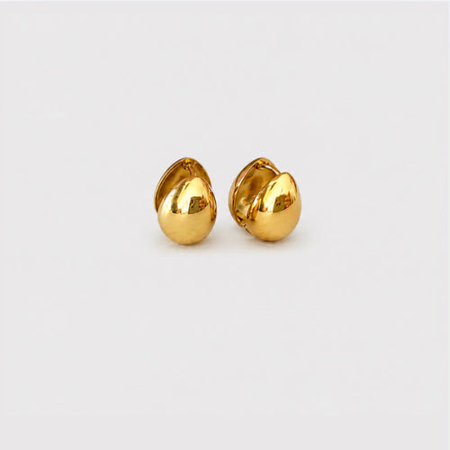 A pair of small, polished gold stud earrings shaped like stylized teardrops or leaves, displayed on a clean, light gray background.