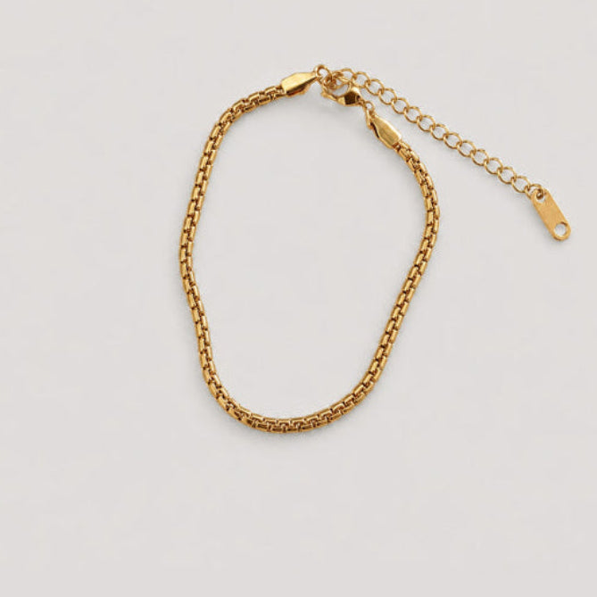 A gold chain bracelet with a lobster clasp and an adjustable extension chain, displayed on a light gray background.