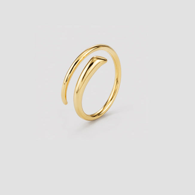A polished gold wrap ring with a modern, open spiral design, shown on a neutral light gray background.