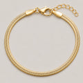 A gold-colored snake chain bracelet with a lobster clasp and extender chain, displayed on a neutral light gray background.