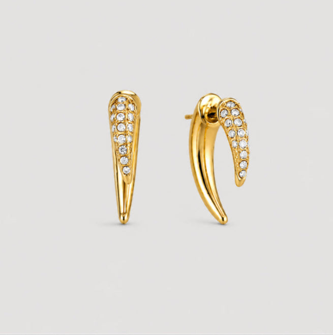 A pair of gold crescent-shaped hoop earrings with pavé-set clear stones along the front, displayed on a light gray background.